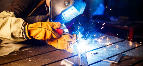 Worker cutting metal with plasma equipment on plant.